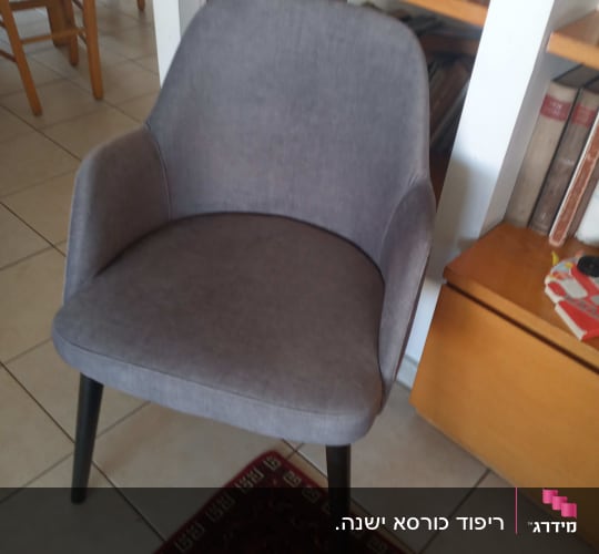 כיסא מרופד אפור עם רגליים שחורות על שטיח